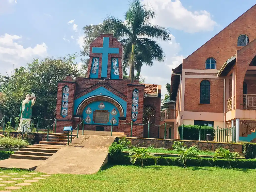 A brick church with a teal cross above its entrance