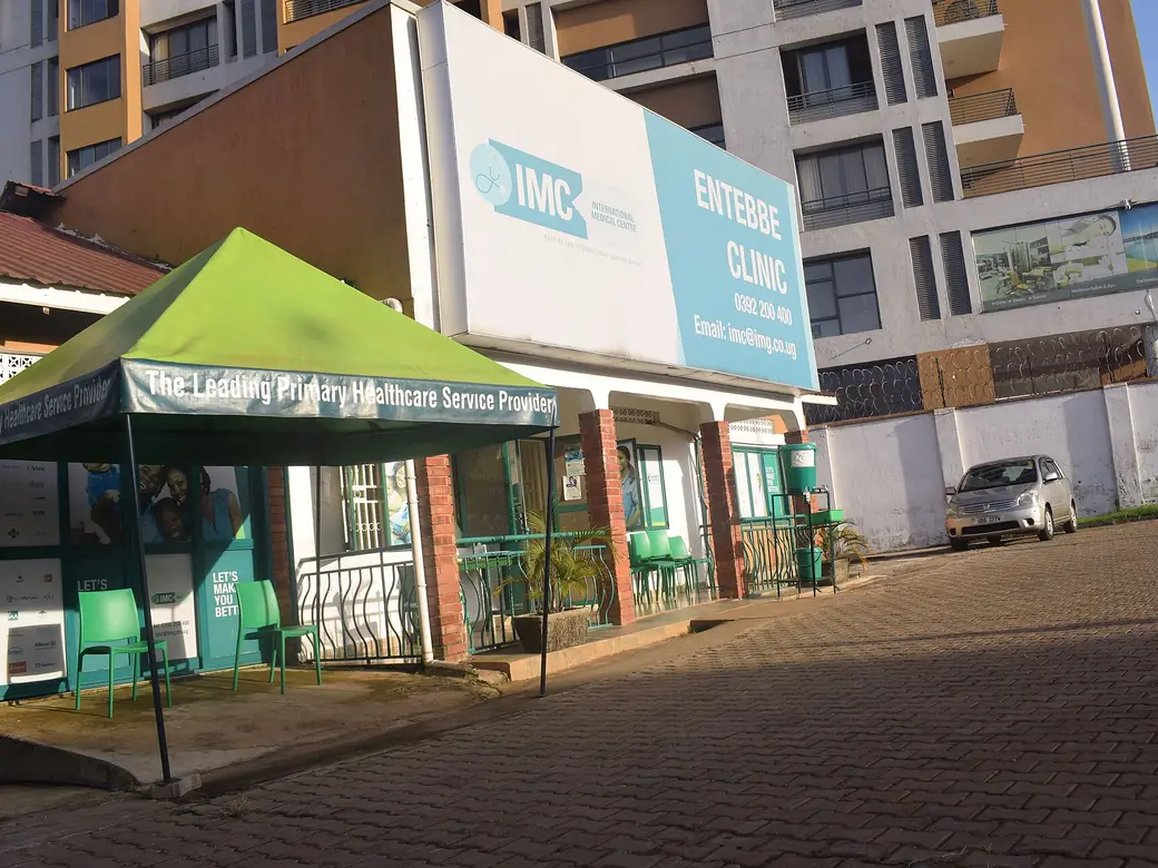 A clinic front with a green canopy and a large signboard