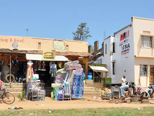 A row of small shops with goods displayed out on the pavement