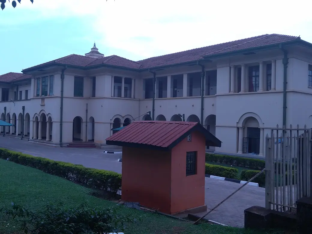 A colonial-style court building with a small guard hut in front