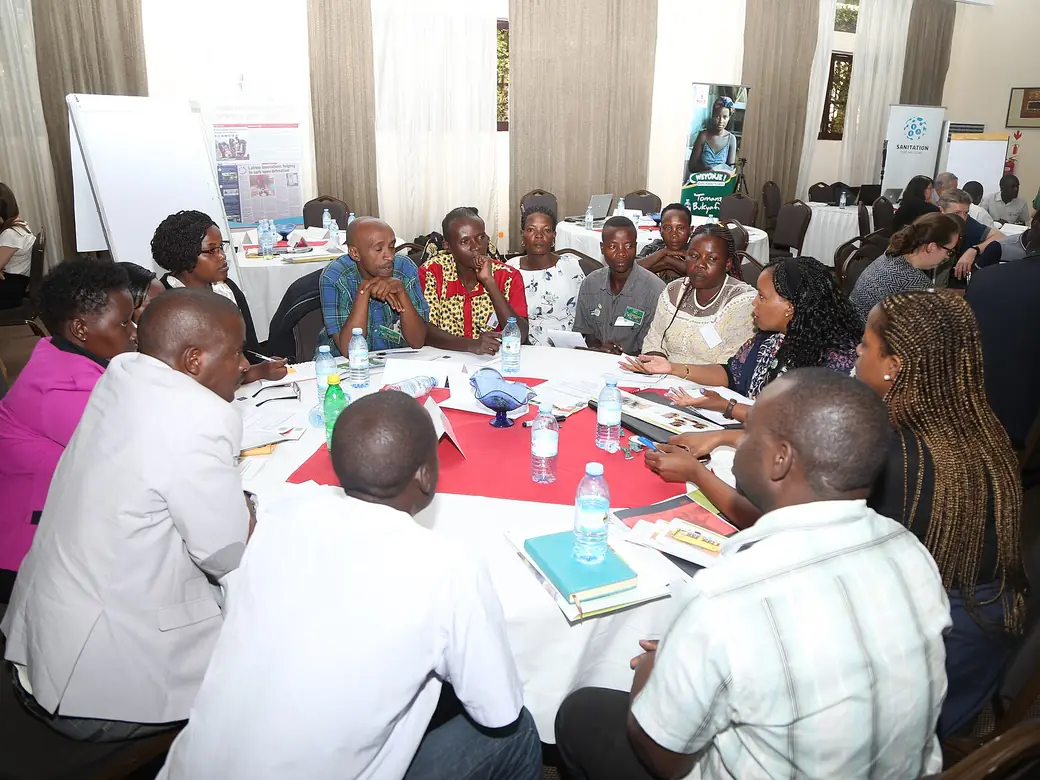 People seated around tables at a workshop discussion