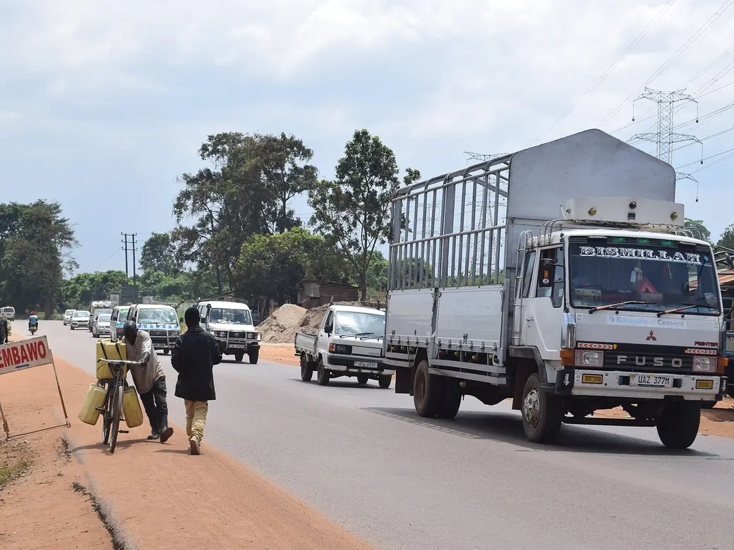 A freight truck driving along a busy town road